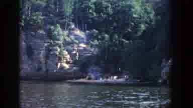 Wisconsin (1964): A Group Of Tourist Men Walking Through A River Mountain In The