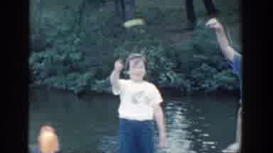 Wisconsin (1964): Woman Wearing Yellow Dress Tries To Keep From Falling Into Water