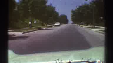 Woodland Hills California (1969): Car Drives Down Road With Leafy Trees Along The