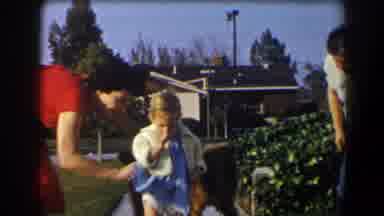 California-1958: Nanny Helping Toddler Walk With Dog In Suburban Yard