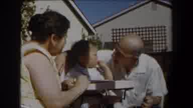 California (1958): Man Wearing White Shirt Talks To Baby Sitting In White