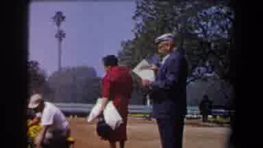 California (1958): Old People In A Plaza Some Sitting On A Bench Others Watering