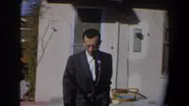 California (1958): A Man In Suit Smiles At A Kid As He Approaches The House
