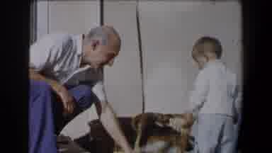 California (1958): Old Man And Young Boy Playing With Dog Outside House