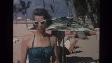 Hawaii (1961): An Older Woman Sits Down In A Chair To Suntan On The Beach