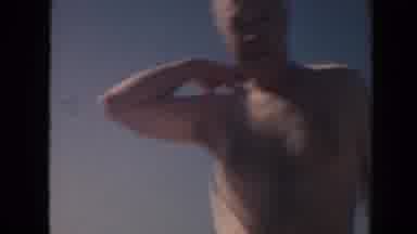Hawaii (1961): Shirtless Older Man On A Beach With Gentle Ocean Waves And Sand