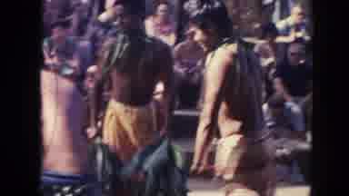 Hawaii (1961): Three Hal-Clad Men Roasting An Animal During A Festival With People