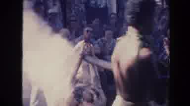 Hawaii (1961): A Group Of Natives Cooking A Orc Over A Fire With Some Orange