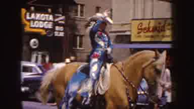 South Dakota-1954: Woman In Rodeo Outfit Rides Horse In Parade