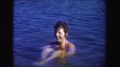 South Dakota (1954): Lady Floating In Water While Child Snorkels With Toy Scuba
