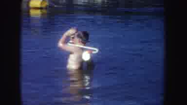 South Dakota (1954): Boy Wearing Silver Scuba Gear Dives Underwater On A Sunny Day