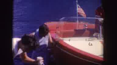 South Dakota (1954): Two Women Stand Near Red And White Boat On A Sunny Day