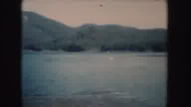 South Dakota (1954): People On A Small Lake With Forested Hills On The Horizon
