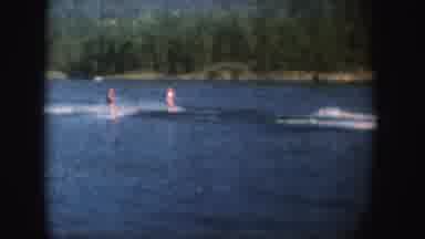 South Dakota (1954): Two People Water skiing On Blue Lake On A Bright Sunny Day