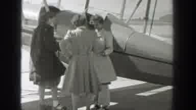 Wyoming (1939): Three Women Stand Next To Airplane On A Sunny Windy Day