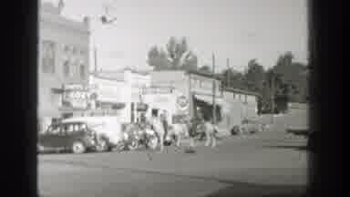Wyoming (1939): People Ride Horses In City With A Lot Of Cars In The Street