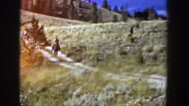 Wyoming (1939): Person Wearing Tan Shirt Rides Black Horse Through Black Field On