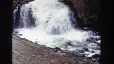 Wyoming (1939): Gaping Waterfall Flowing Into Rocky River With People Swimming