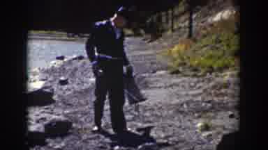 Wyoming (1939): Person Wearing Black Hat Walks Along Shore Of Stream On A Sunny