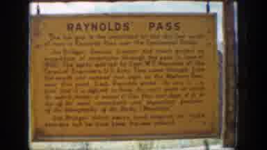 Wyoming (1939): Man Poses For Photo Standing On Reynolds Pass Sign