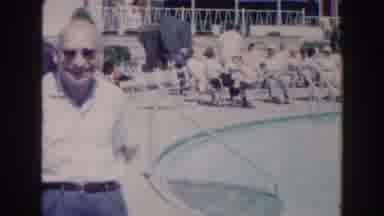 Miami Florida (1960): Man Wearing Sunglasses Points At Blue Pool Then At Four Men