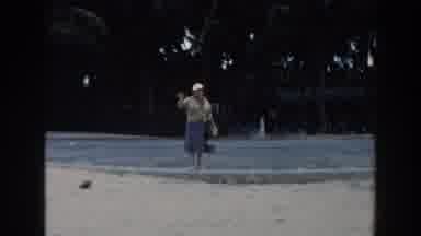 Miami Florida (1960): Older Woman Walking And Picking Up Things On A Sandy Beach
