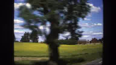 Sweden (1975): Driving Along A Rural Road And Passing A Classic Red Farmhouse