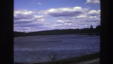 Sweden (1975): Road View Of A Large Blue Lake Surrounded By Trees With Cloudy Sky