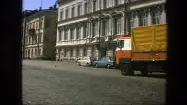 Sweden (1975): Moving Yellow Truck Driving Goods On The Road Near A Building