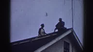 Nebraska (1958): Two Men Sit On The Roof Of A White House Replacing Shingles