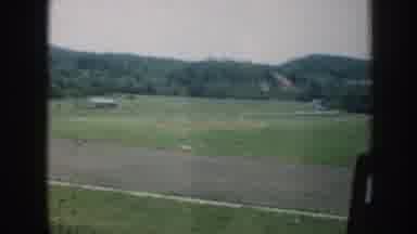 Nebraska (1958): A View From A Car Window Of A Green Field And Some Mountain