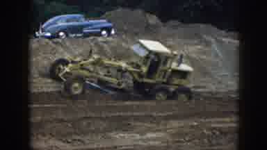 Nebraska (1958): Large Machine Driving Through Field And Plowing Dirt Near Blue
