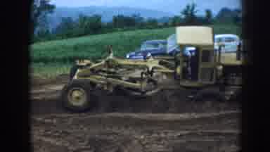 Nebraska (1958): An Area Under Construction With A Yellow Tractor Passing Through