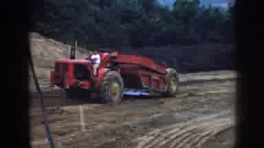 Nebraska (1958): Man Wearing White Shirt Drives Large Red Tractor On A Clear Day