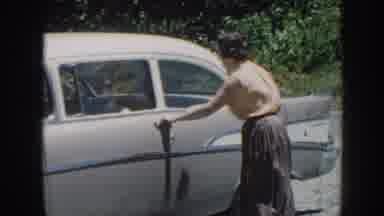 Nebraska (1958): Woman Wearing Pink Shirt Gets Into Gray Car And Drives Away On A