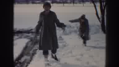 Nebraska (1958): An Adult And Child Playing In The Snow During Winter While A Man