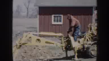 Nebraska (1958): A Man Wearing A Red Hoodie Operating A Yellow Tractor Digging Up