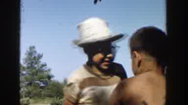 Michigan (1958): Woman Wearing Blue Dress Walks Into Shade On A Sunny Day