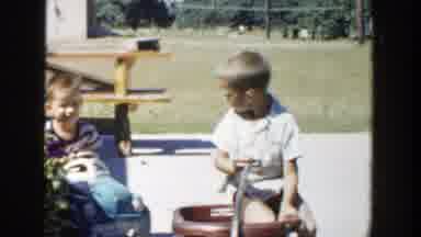 Michigan (1958): A Group Of Kids Playing With Some Pedal Cars At A Backyard With