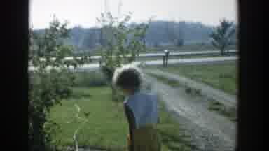 Michigan (1958): Woman Wearing Yellow Shorts Picks Up Black And White Cat From