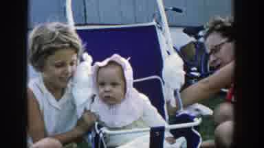 Michigan (1958): Woman Wearing Light Green Shirt Talks To Baby Wearing White Hat