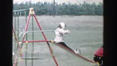Michigan (1958): Two Kids Slide Down Red And Green Slide Of Swing set On A Clear