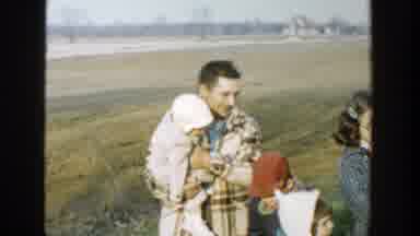 Michigan (1958): Father Walking With His Children And A Newborn On His Lap In An