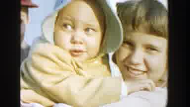 Michigan (1958): A Small Girl Holding A Baby With Both Of Them Wearing Bonnets