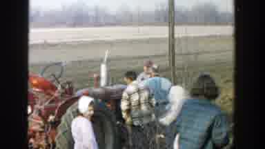 Michigan (1958): People Outside Preparing To Ride A Tractor