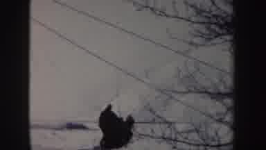 New York (1962): Man Uses Dogs To Pull His Sled Up Snowy Hill
