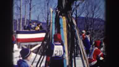New York (1962): Boy Wearing Black Pants Arranges Red Skis In Snow On A Bright