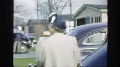 Massachusetts (1949): An Old Lady Heading Towards A Purple Car On A Cold Day With
