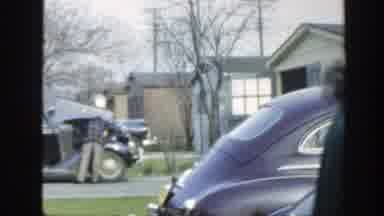 Massachusetts (1949): People Walking Behind A Man Fixing His Car