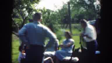 Massachusetts (1949): Several Adults Stand And Sit Talking And Smiling In A Circle